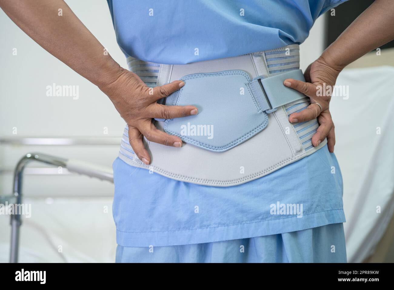 Asian lady patient wearing back pain support belt for orthopedic lumbar ...