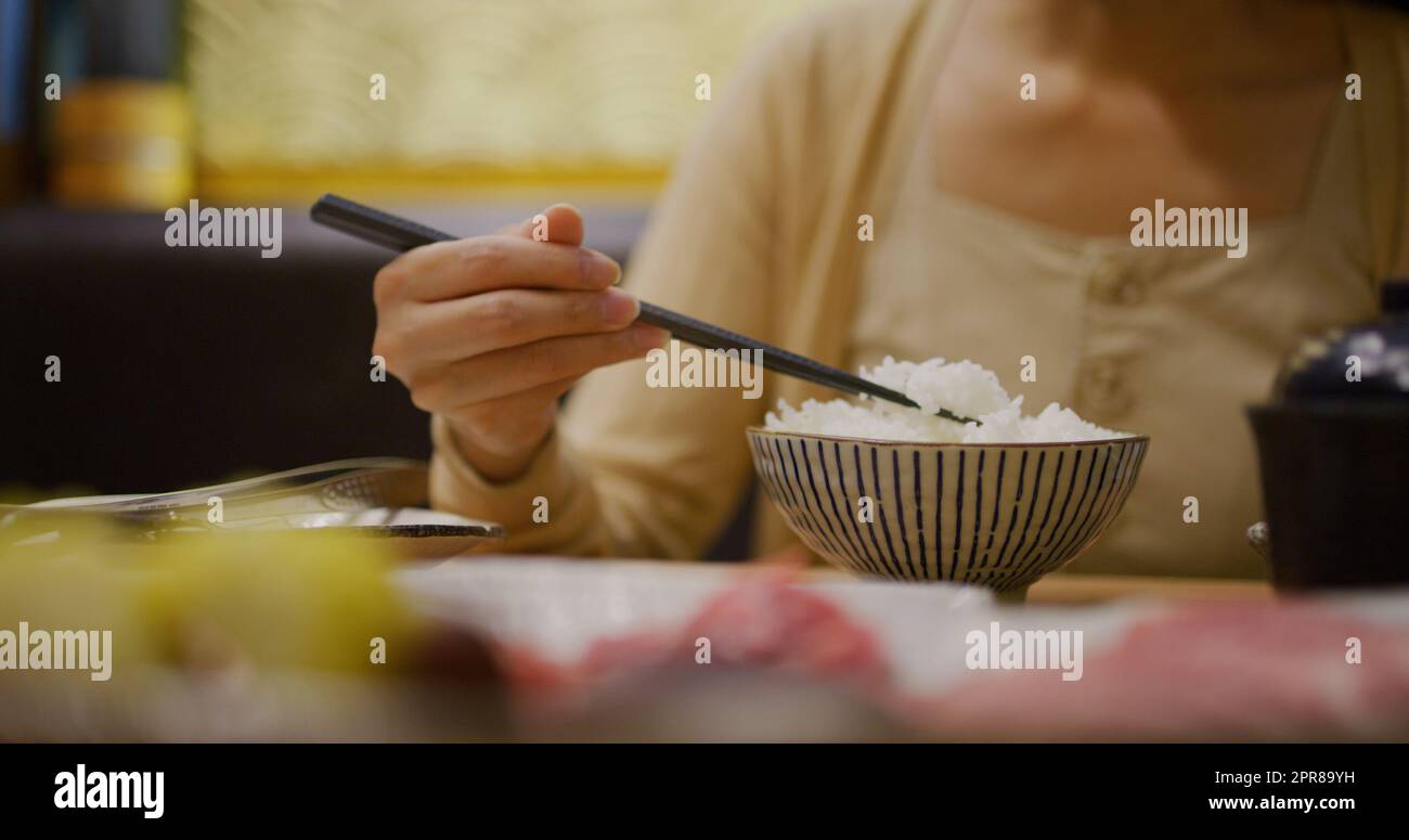 Woman eat her rice in japanese restaurant Stock Photo - Alamy