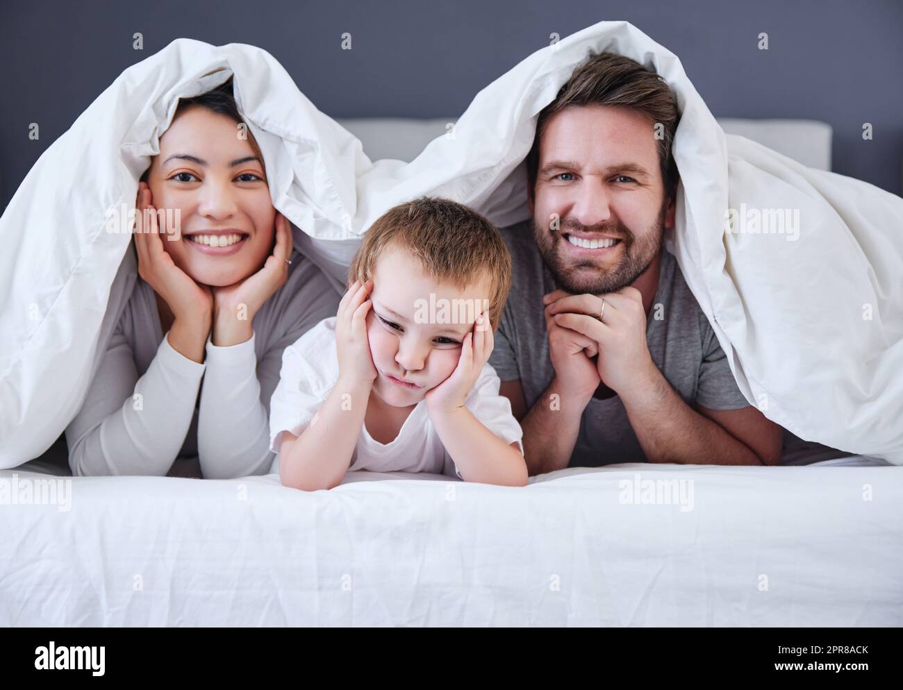 He teaches us new poses. Shot of a young family relaxing at home. Stock Photo