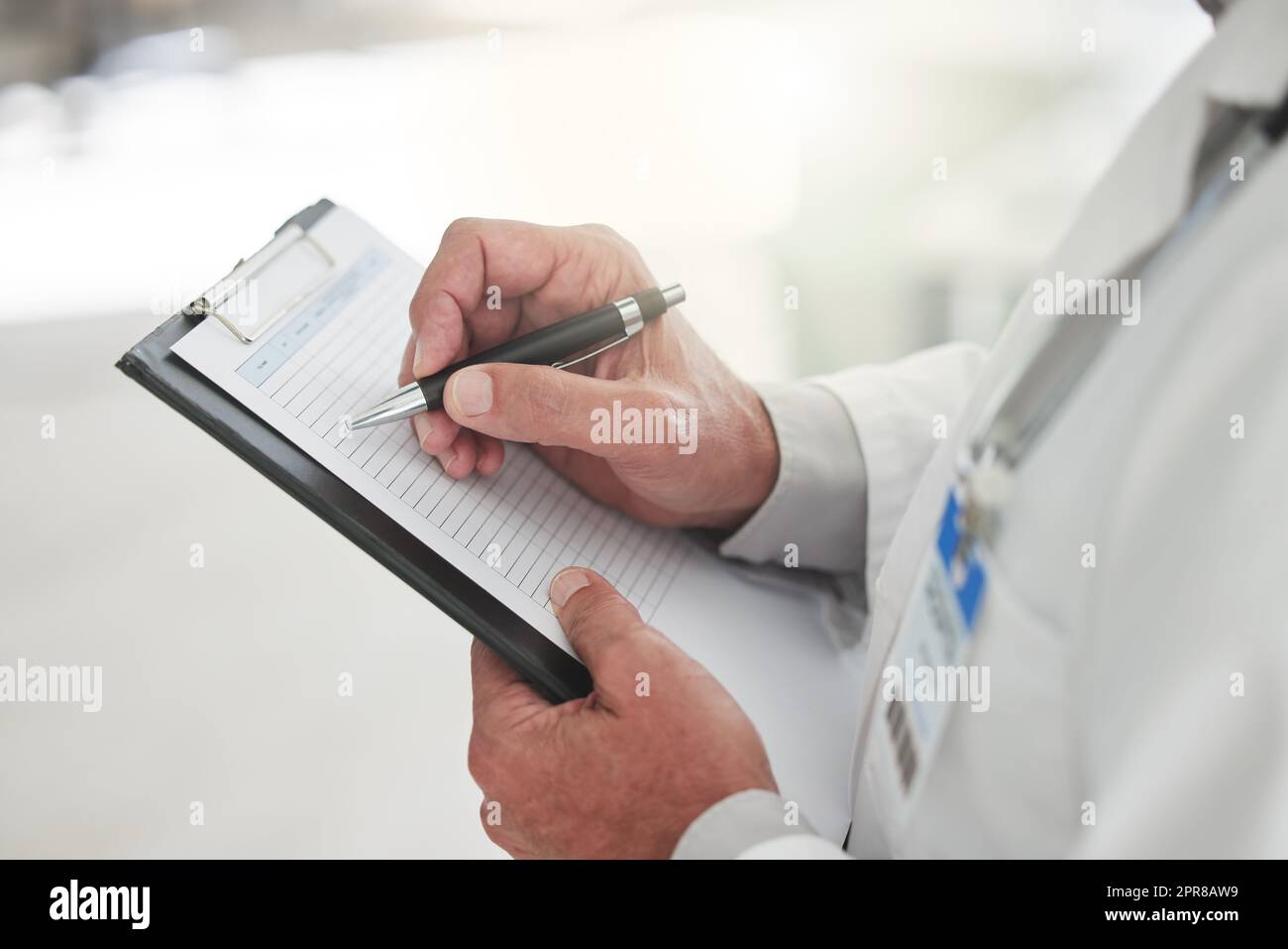 Plans are better made on paper. Shot of an unrecognizable doctor writing of a form at a hospital. Stock Photo