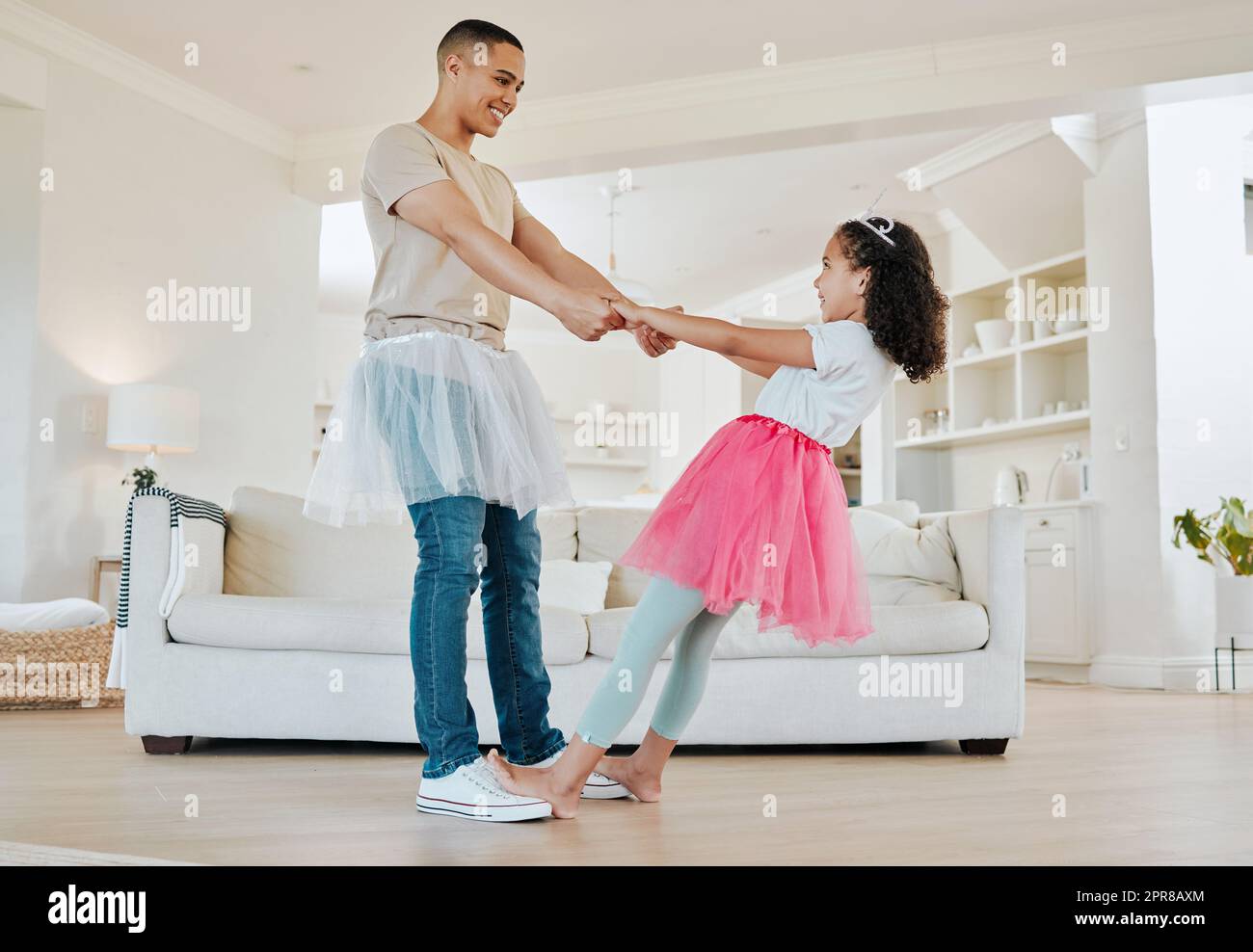 You spin me right round dad. Shot of a father dancing with his daughter in the living room at home. Stock Photo