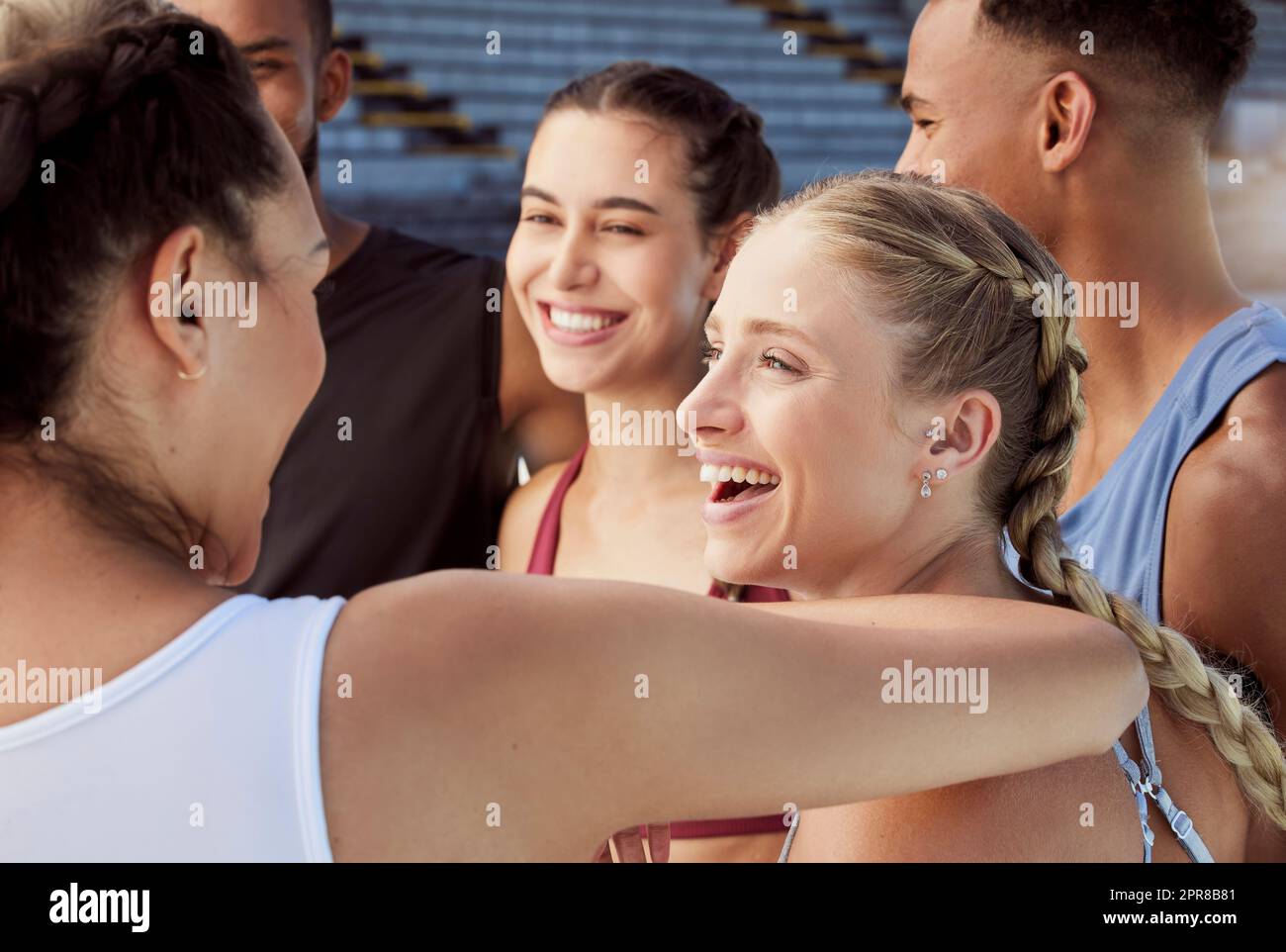 Diverse group of athletes standing together and smiling after practice. Young, happy, fit, active people bonding after training in sports centre. Athletic men and women after healthy exercise workout Stock Photo