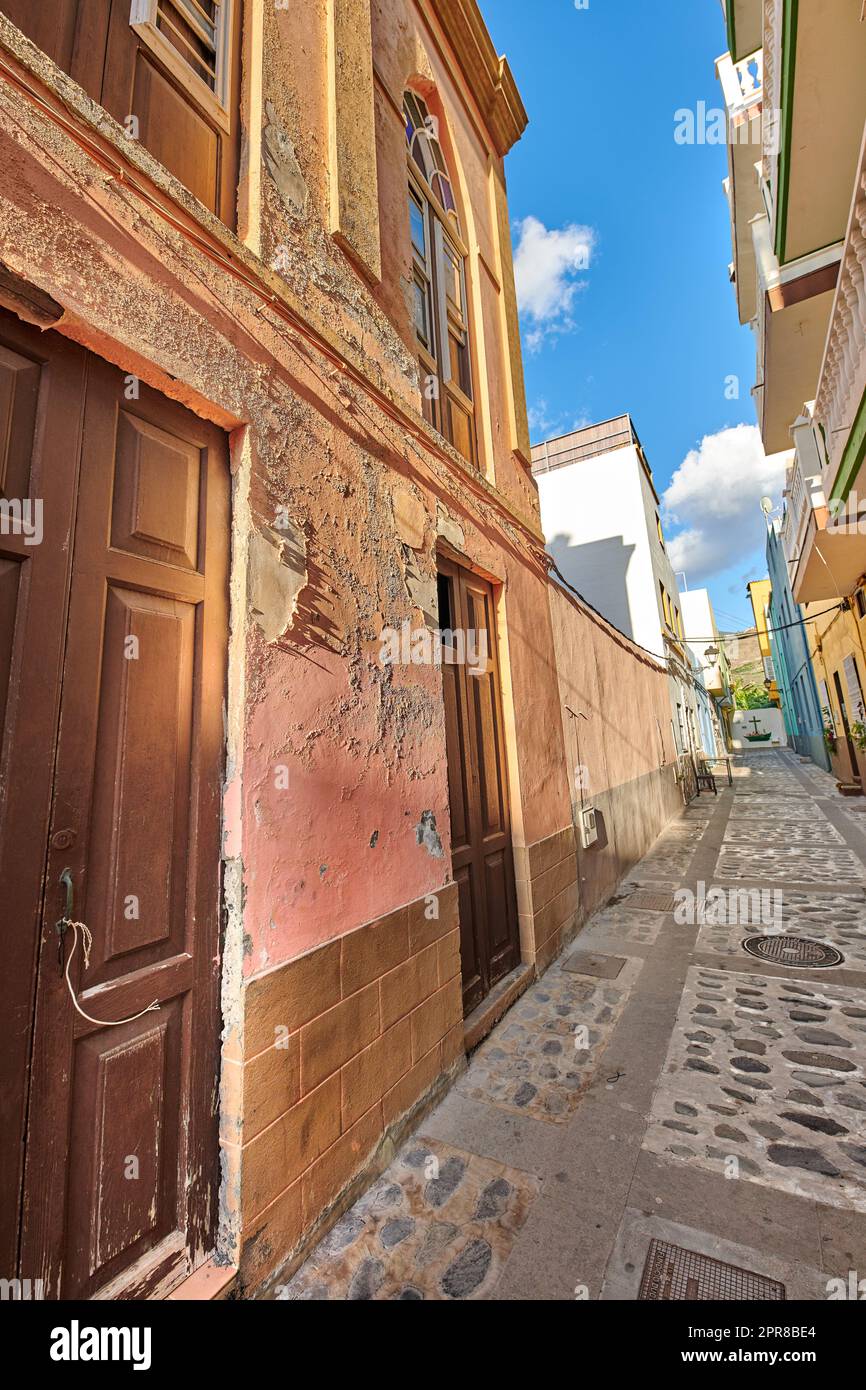 Scenic view of old historic houses, residential buildings, traditional infrastructure in small alleyway, street, road. Tourism, travel destination abroad and overseas in Santa Cruz de La Palma, Spain Stock Photo