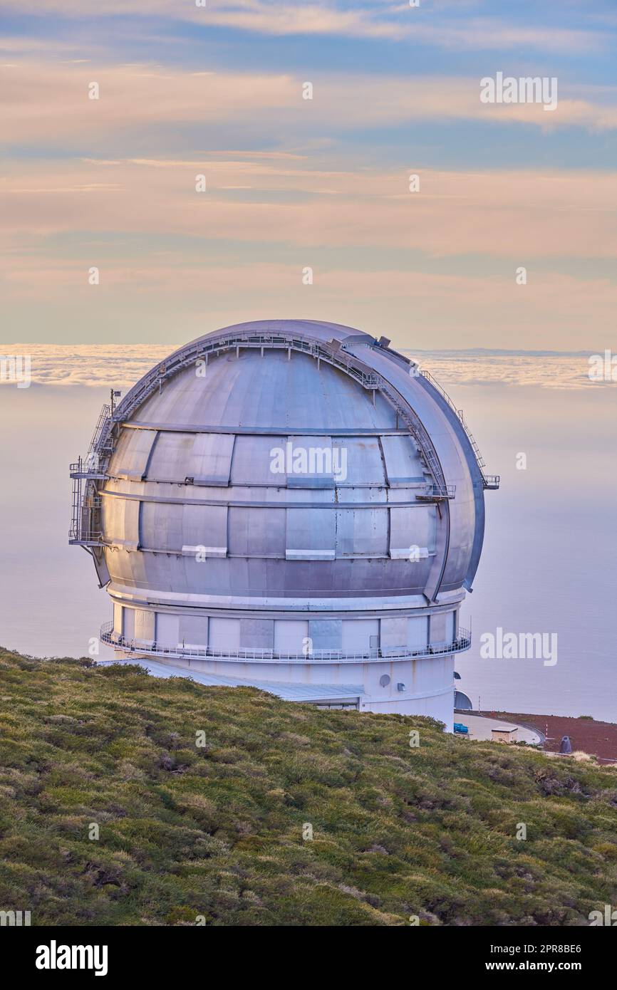 Scenic view of an astronomy observatory dome in Roque de los Muchachos, La Palma, Spain. Landscape of science infrastructure or building against blue sky with clouds and copyspace abroad or overseas Stock Photo