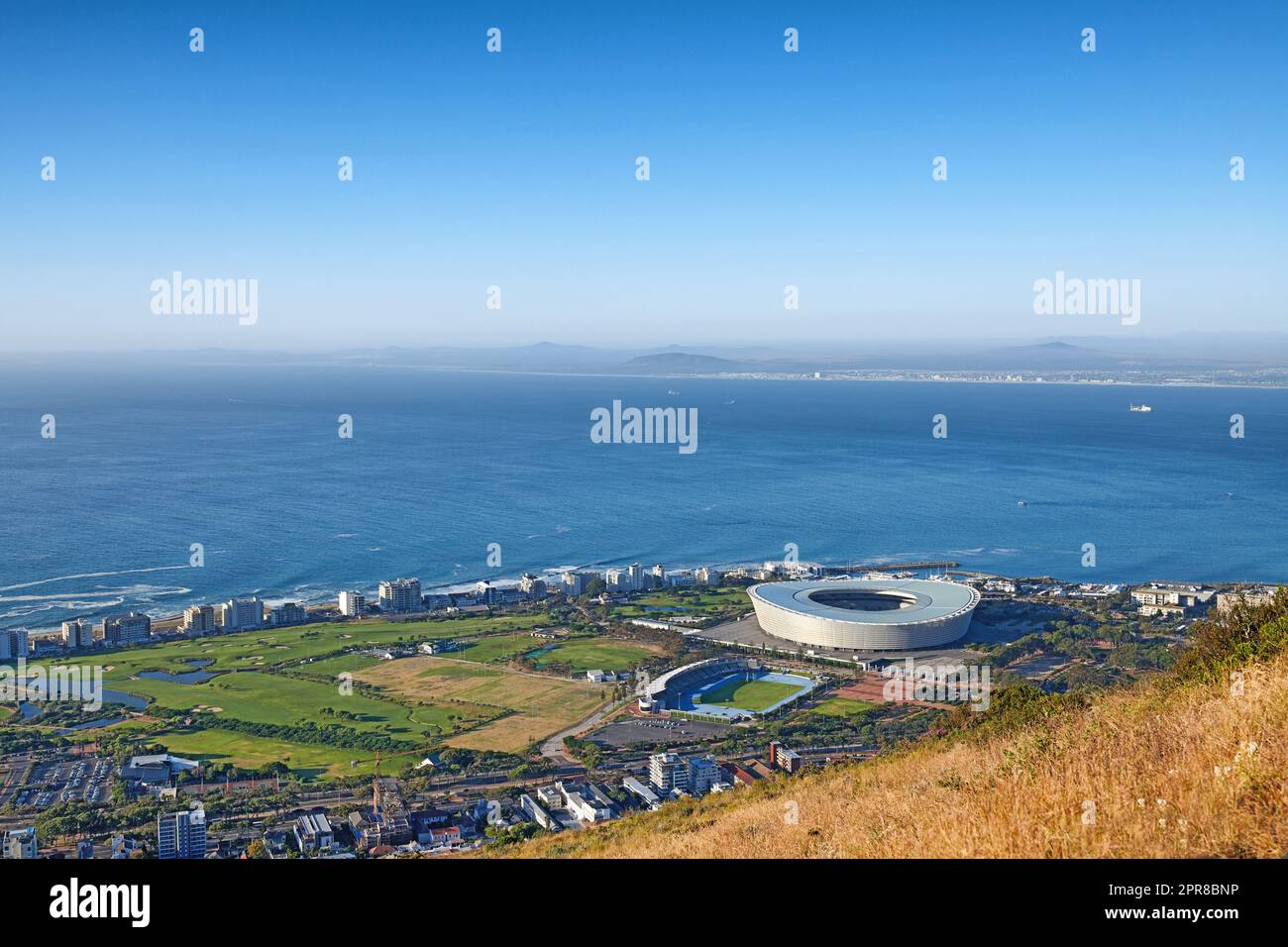Above panoramic photo of a the central business district of Cape Town, Western Cape, South Africa. A busy peninsula where land meets sea against a cloudscaped blue sky. A beautiful mountainside city Stock Photo
