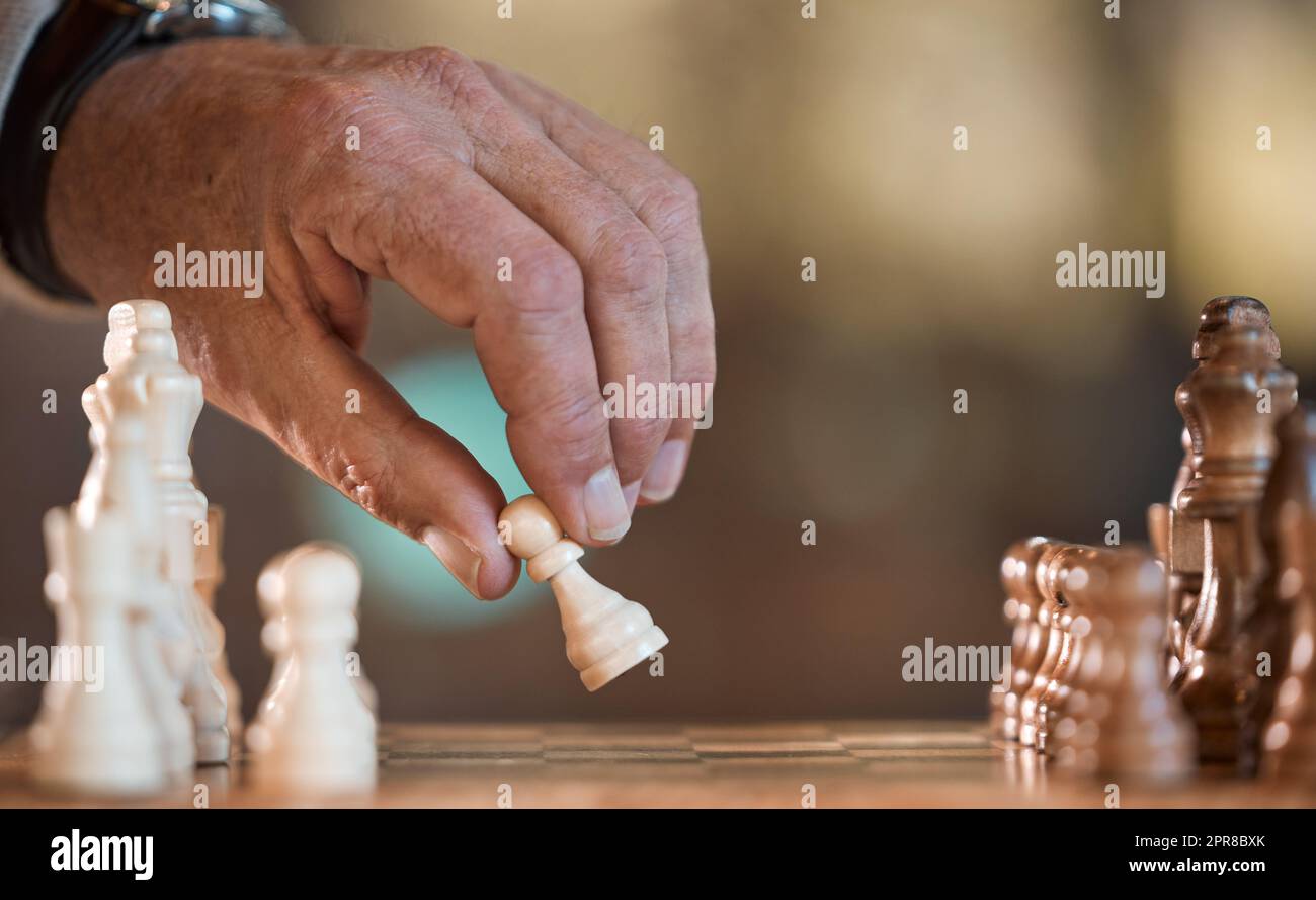 Chess is a mind game. an unrecognisable man playing a game of chess