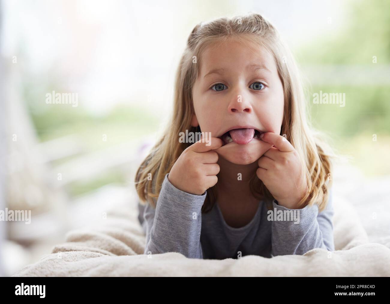 I wonder if my face will stay this way. a young girl making funny faces