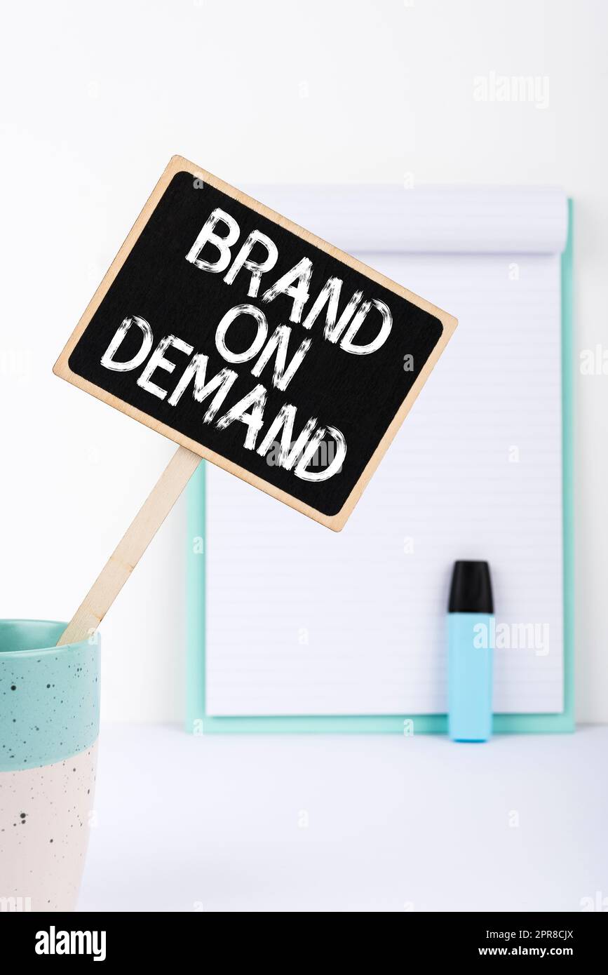 Hand writing sign Brand On Demand. Concept meaning Intelligence needed Smart thinking Support Assistance Small Blackboard With Important Message In Cup On Desk With Clipboard. Stock Photo