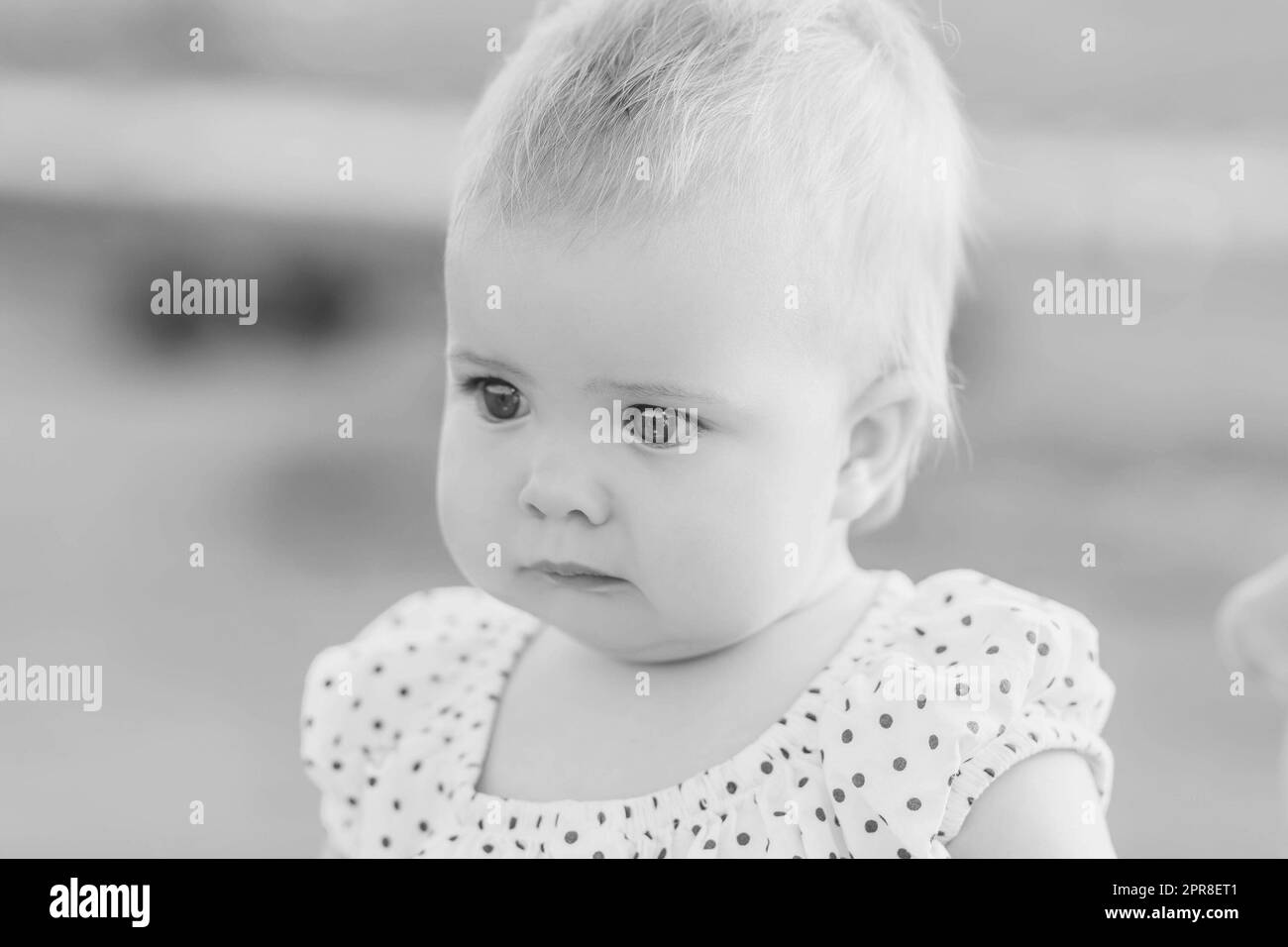 black and white photo of adorable baby in polka dot dress Stock Photo