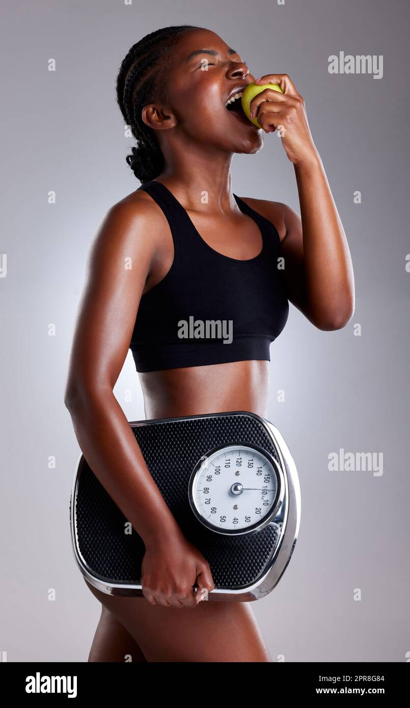 https://c8.alamy.com/comp/2PR8G84/healthy-eating-and-regular-exercise-can-help-you-lose-weight-safely-studio-shot-of-a-sporty-young-woman-eating-an-apple-while-holding-a-scale-against-a-grey-background-2PR8G84.jpg