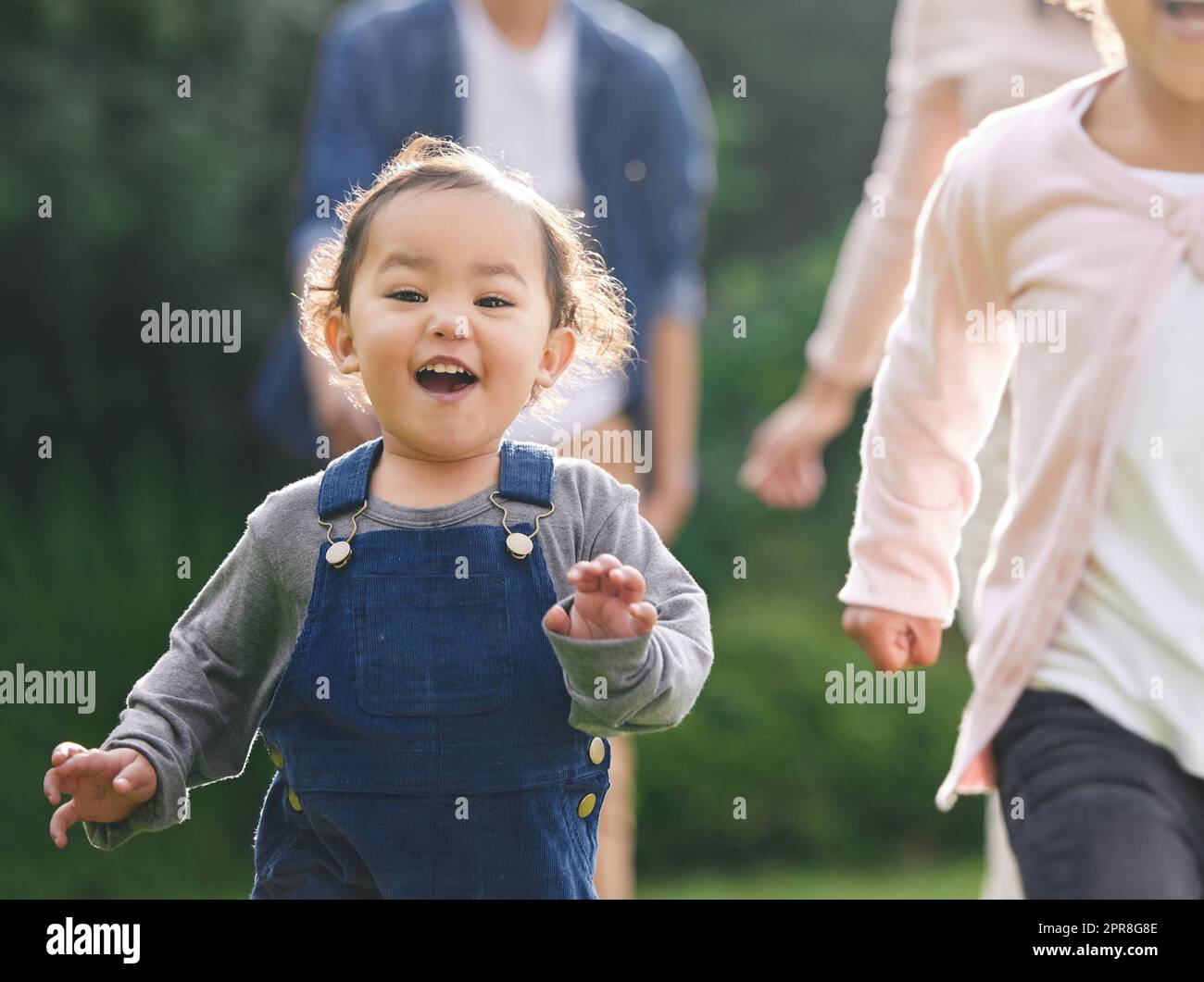A good time to laugh is anytime you can. Portrait of an adorable little girl having fun with her family outdoors. Stock Photo