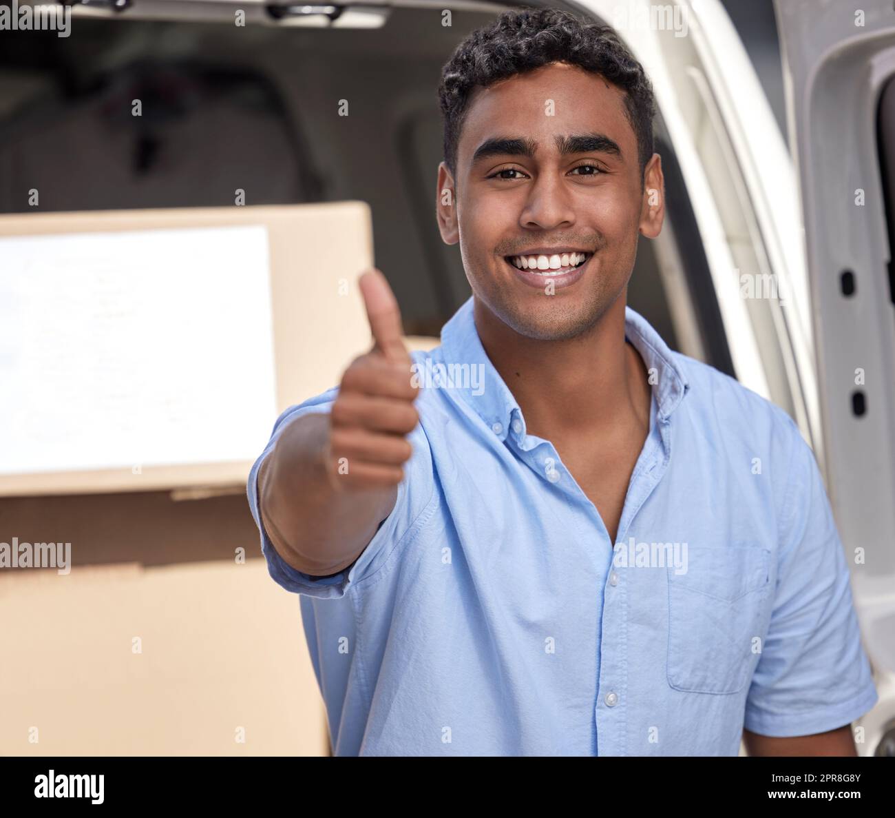 All good to go. Portrait of a young delivery man showing thumbs up