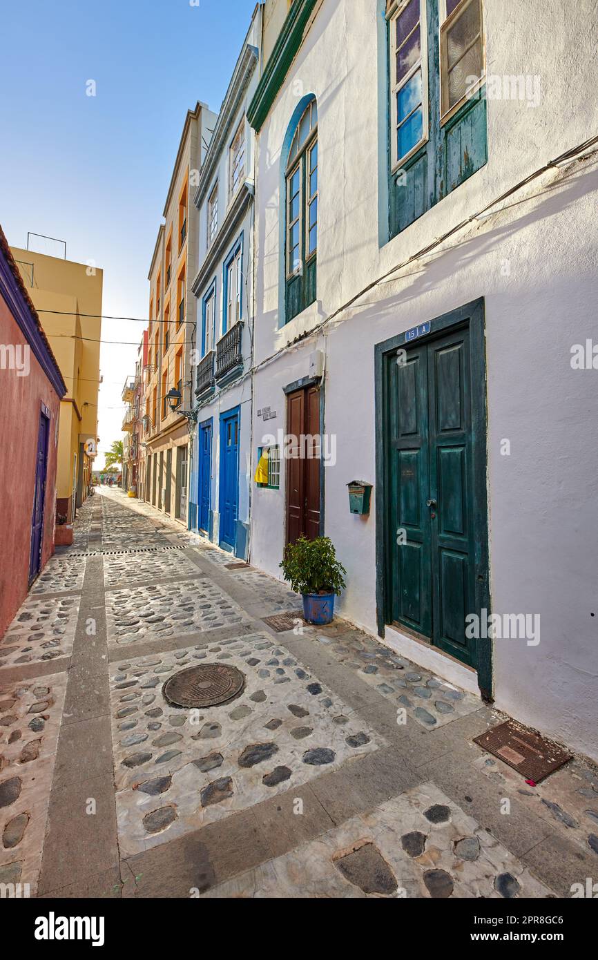 City view of residential houses or buildings in quiet alleyway street in Santa Cruz, La Palma, Spain. Historical spanish and colonial architecture in a tropical village and famous tourism destination Stock Photo