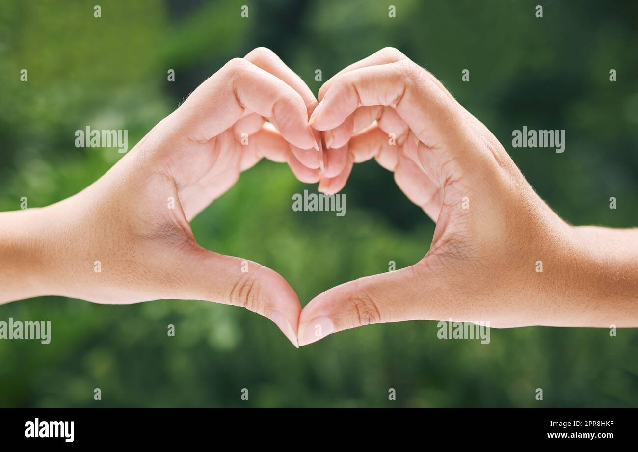 Closeup of hands making a heart. Two peoples hands making a heart in nature as the concept of loving the environment. Hands making the heart sign Stock Photo