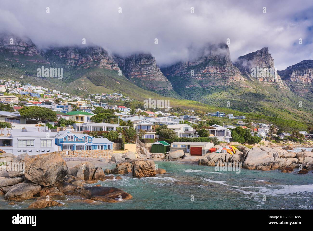 Landscape view of a seaside town along the mountain on a cloudy day in Cape Town, South Africa. Scenic view of a quiet and secluded residential area on the coast for tourists and holidays in summer Stock Photo