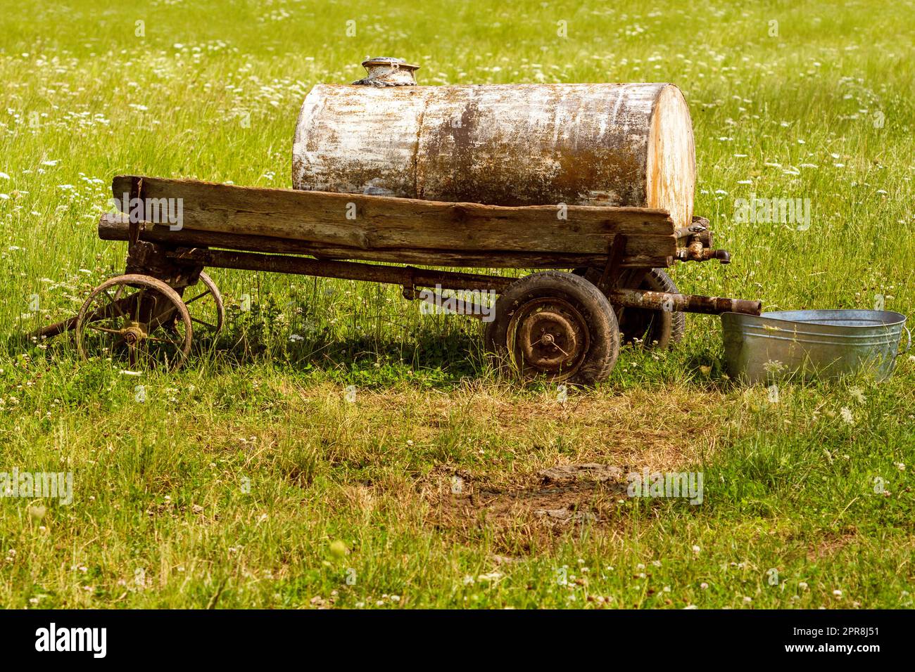 Old mobile water tank for watering grazing cattle in a pasture Stock