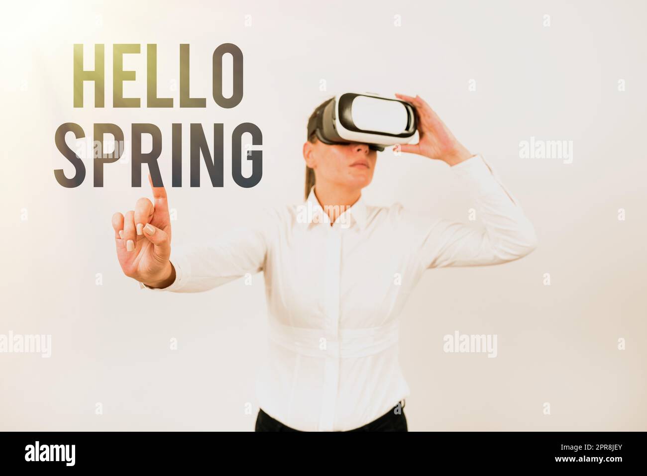 Conceptual caption Hello Spring. Business idea Welcoming the season after the winter Blossoming of flowers Woman Wearing Vr Glasses And Pointing On Important Message With One Finger. Stock Photo