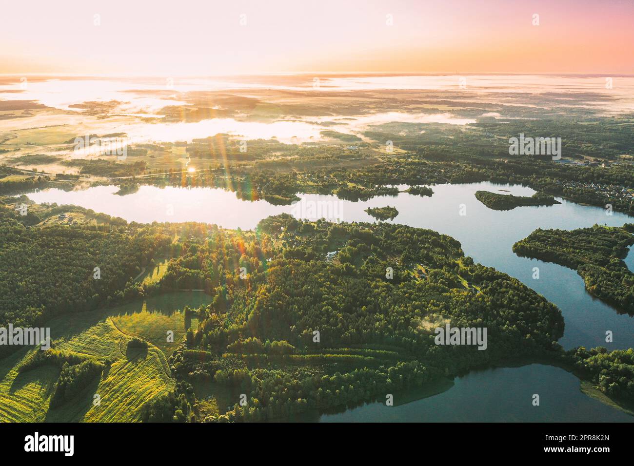 Lyepyel District, Vitebsk Region, Belarus. Aerial View Of Sunset Sunrise Above Residential Area With Houses In Countryside. Morning Fog Above Lepel Lake. Bird's Eye View Of Lepel Lake Stock Photo