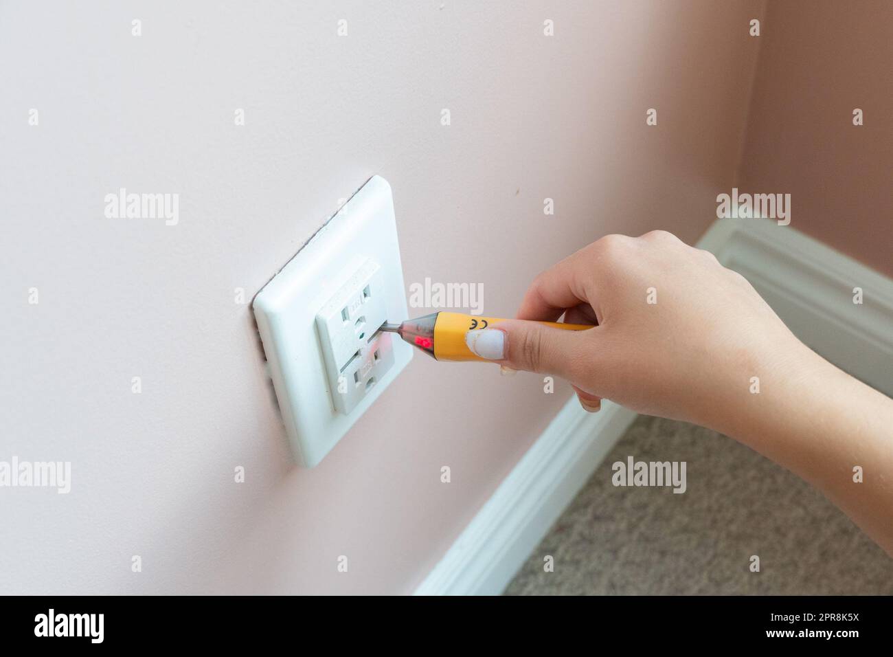 Checking the presence of voltage in the electrical outlet Stock Photo