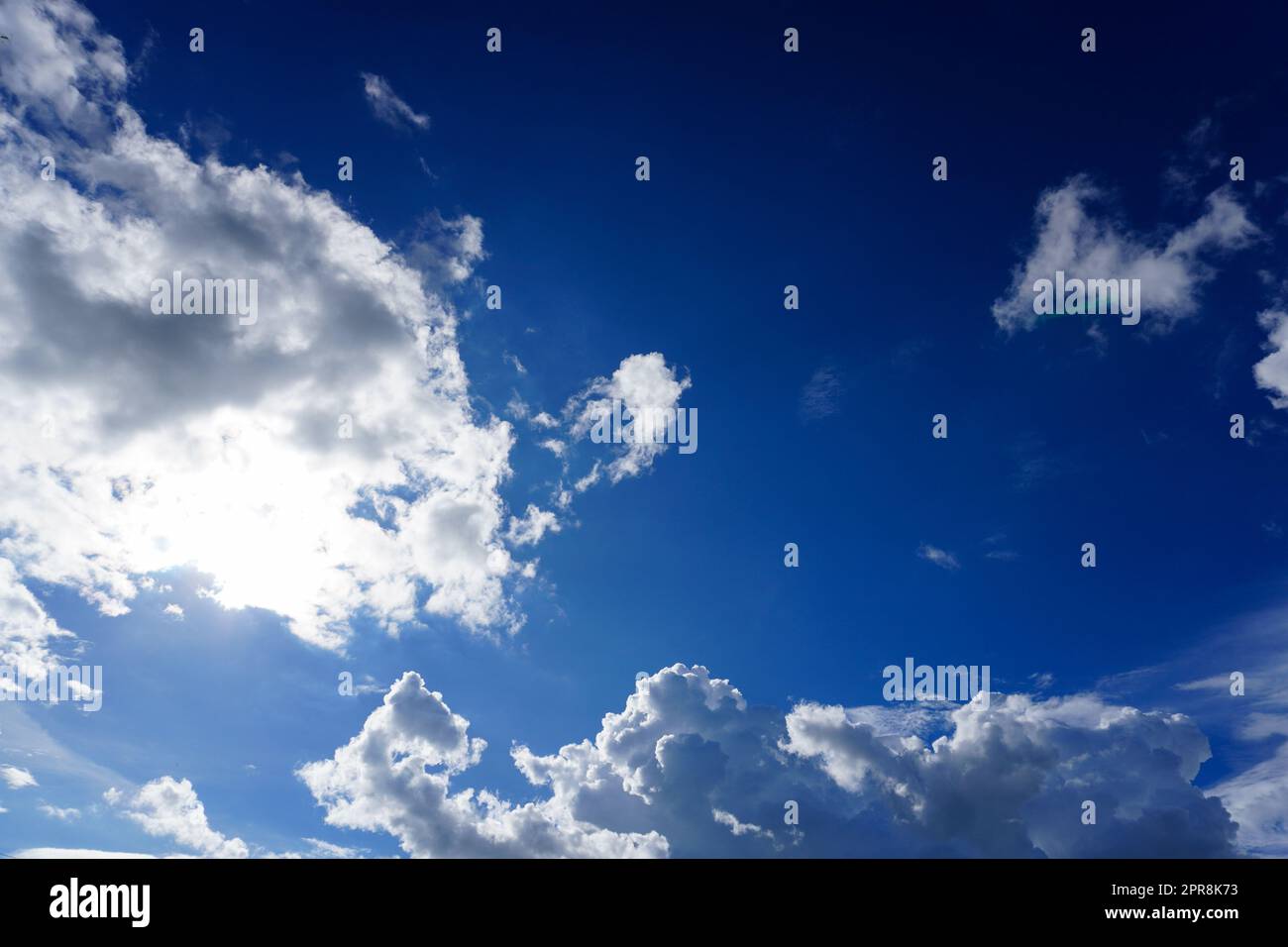 Blue sky with clouds and sun shines bright in the daytime in summer Stock Photo