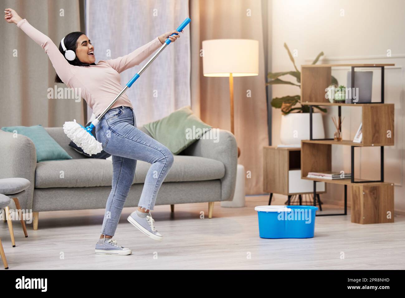 Turning chores into a dance party. a young woman listening to music and