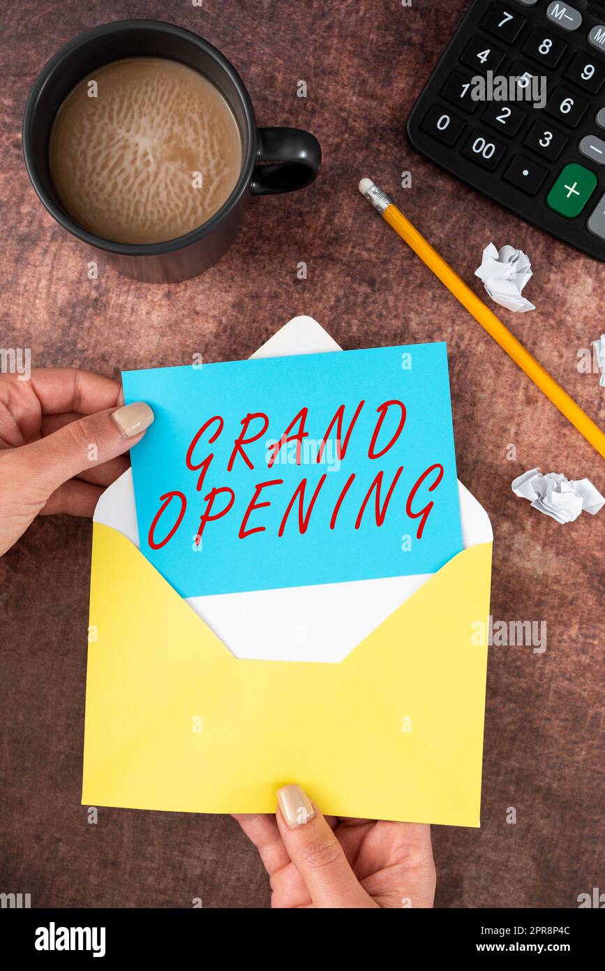 Text showing inspiration Grand Opening. Word for Ribbon Cutting New Business First Official Day Launching Woman Holding Blank Letter With Coffee And Stationery Over Wood. Stock Photo