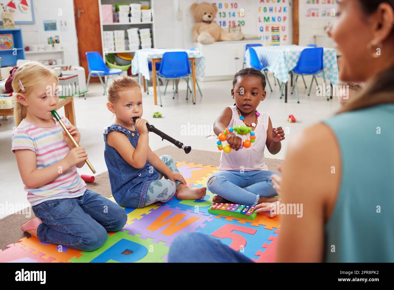 Musical instruments helps the body and mind work together. children learning about musical instruments in class. Stock Photo
