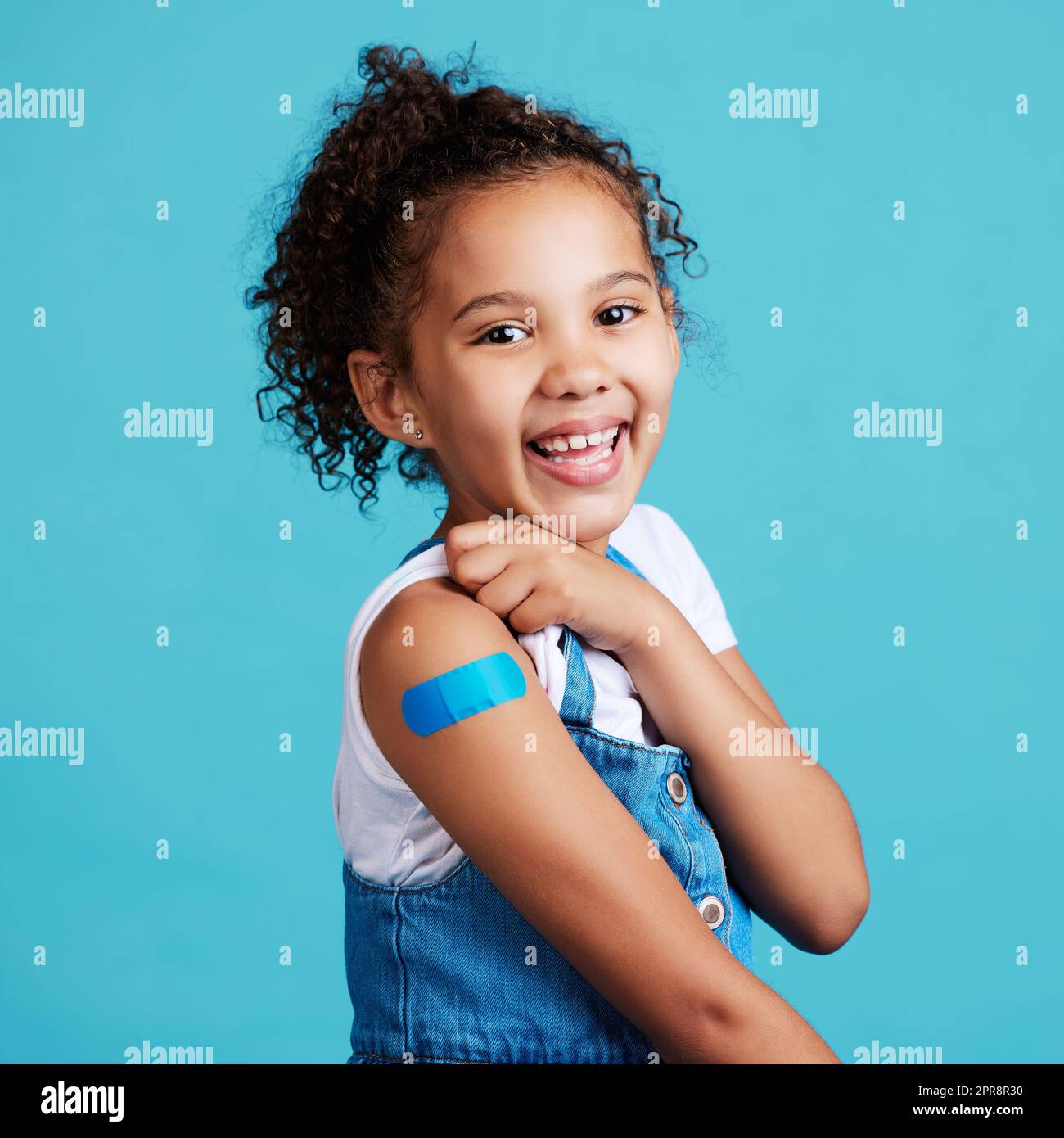 Im a big girl now. a little girl showing off a bandaid on her arm. Stock Photo