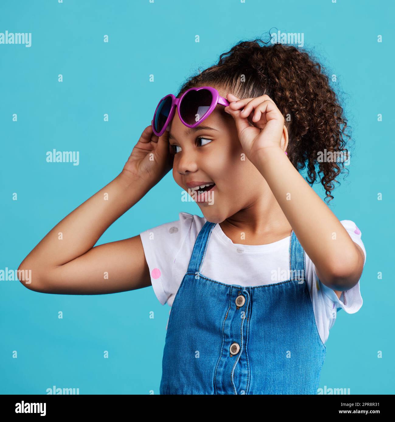 Everyone thinks that Im super adorable. an adorable little girl posing against a blue background. Stock Photo