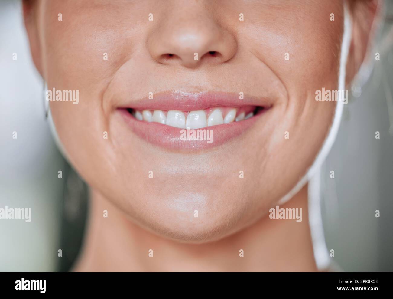 Closeup of unknown smiling woman alone in gym. Happy headshot caucasian trainer showing clean teeth while standing after routine workout in health club. Coach in fitness centre for exercise training Stock Photo