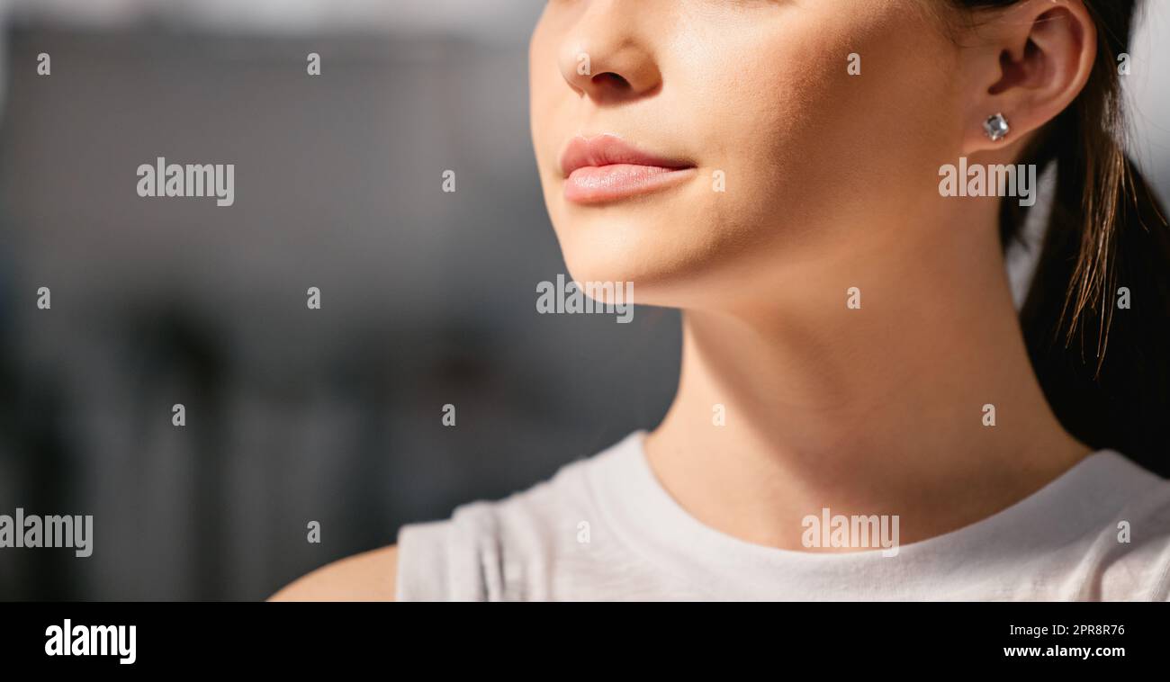 Closeup of one focused caucasian woman exercising in a gym with copyspace on the side. Face of a determined and motivated female athlete with healthy skin looking thoughtful in a fitness centre Stock Photo