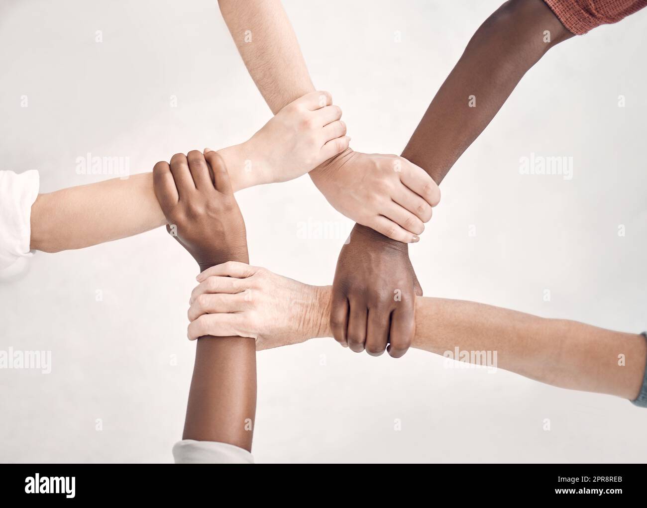 Businesspeople gripping and holding each others wrists in an office at