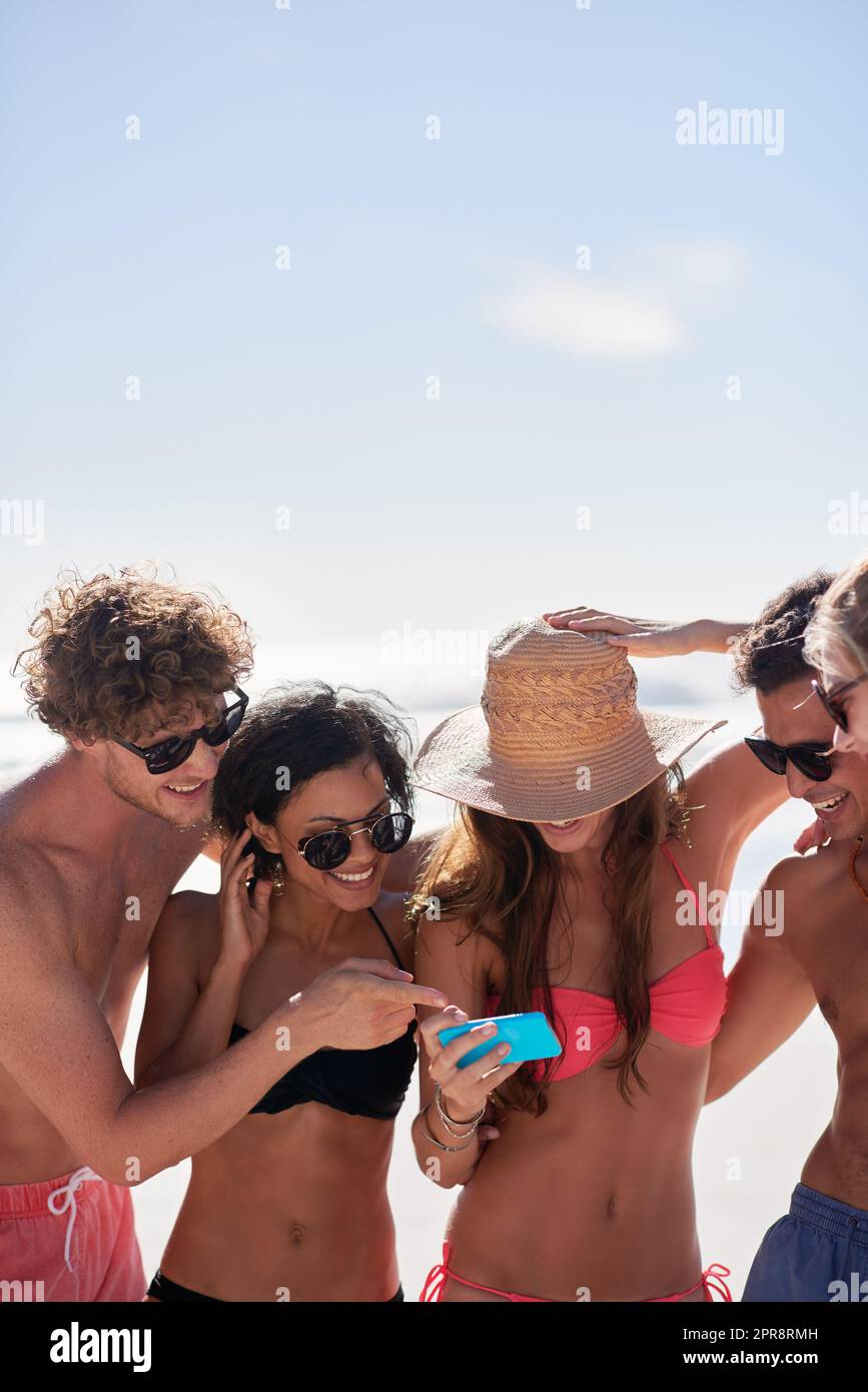 Remembering the good times. a group of friends taking selfies on the beach. Stock Photo