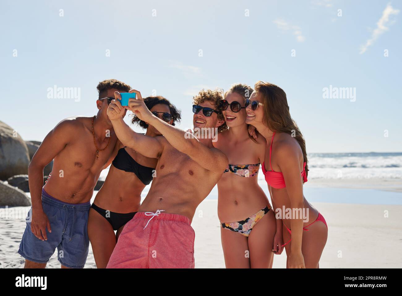 Say cheese for me. a group of friends taking selfies on the beach. Stock Photo