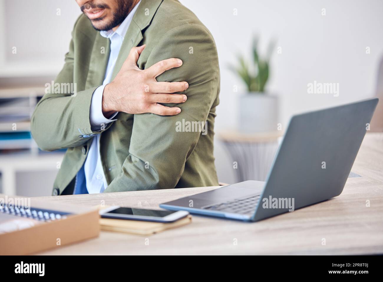 Why is my arm so stiff. an unrecognizable businessman struggling with