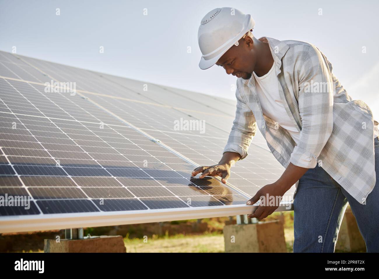 It helps to plan everything out. a young man standing in front of solar panel on a farm. Stock Photo