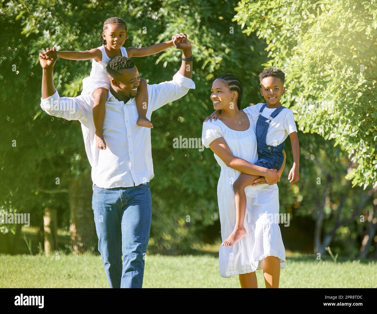 Loving them comes naturally. a couple spending time outdoors with their two children. Stock Photo