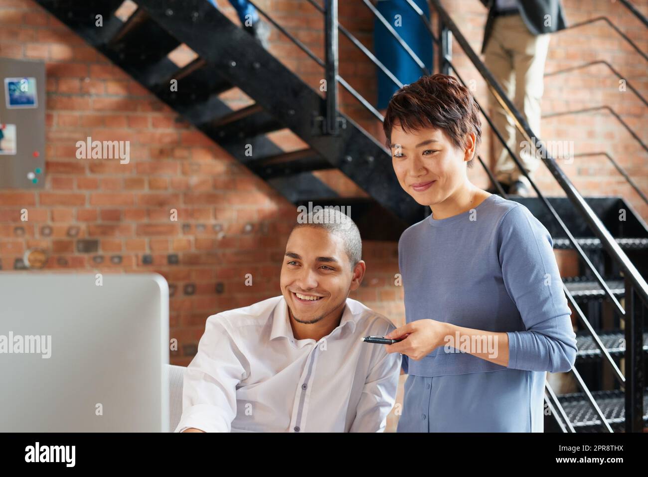 All our plans are looking amazing so far. two businesspeople working together on a computer in an office. Stock Photo