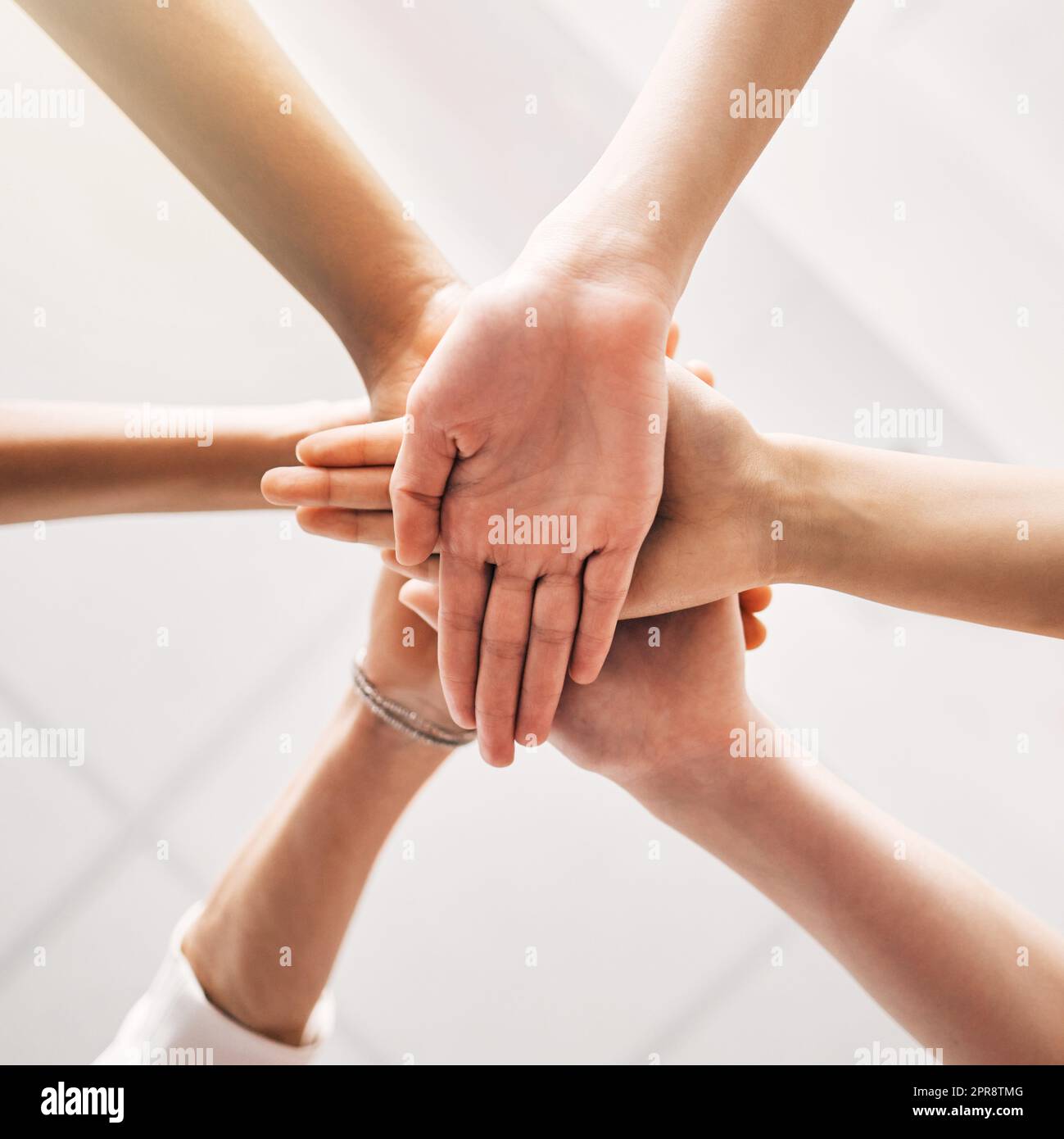 Keeping the team spirit alive. a group of unrecognizable businesspeople stacking their hands at work. Stock Photo