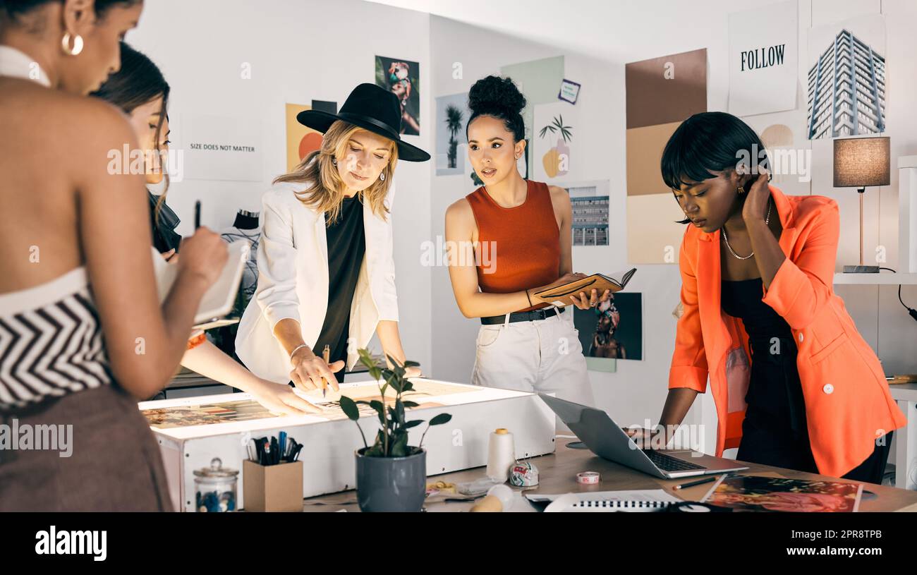 High-pressure is an understatement. a group of designers collaborating at a workshop together. Stock Photo