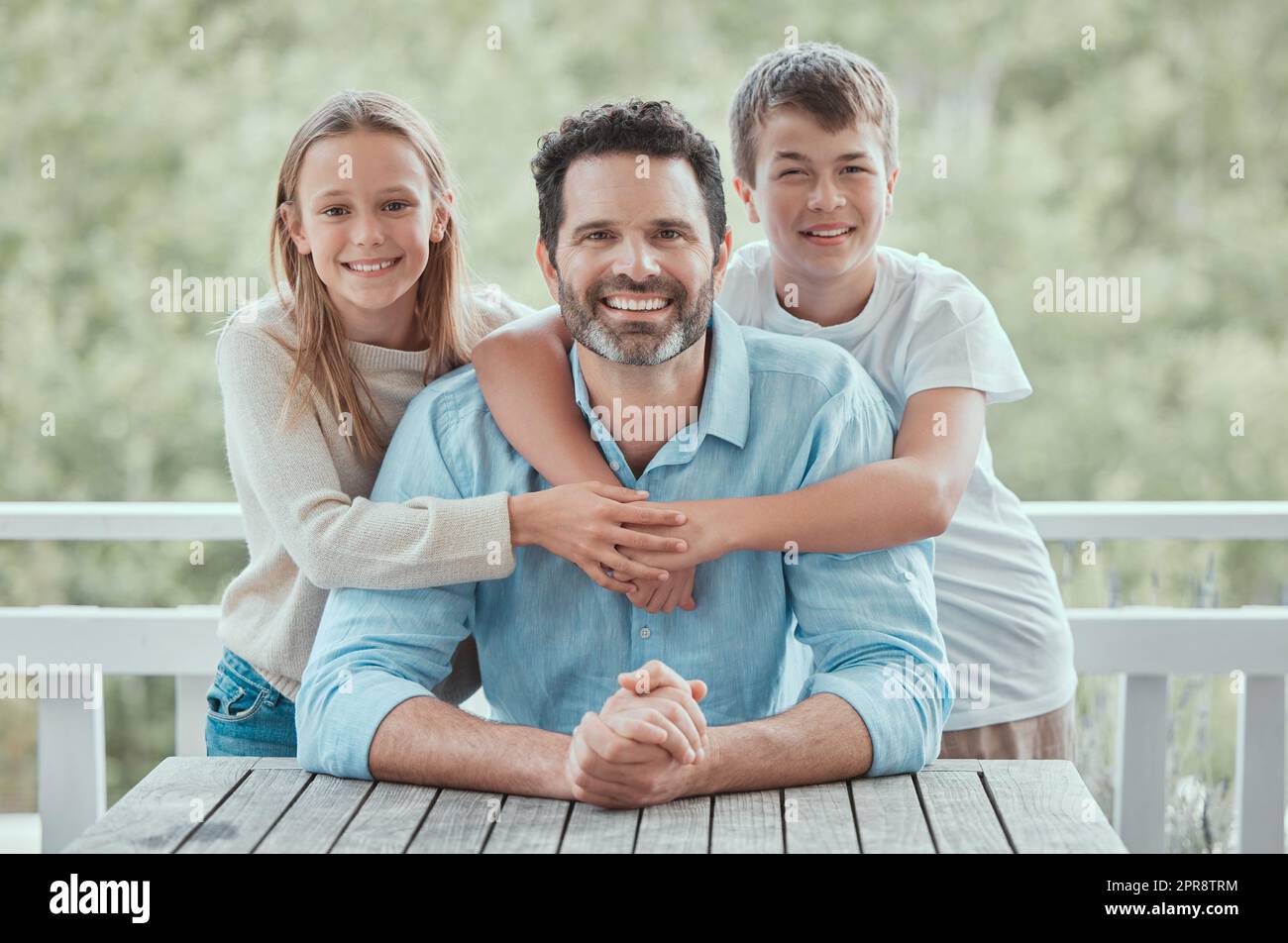 They love their dad. a father spending time with his children at home. Stock Photo