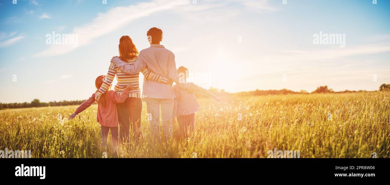 Happy family in the nature together on the evening sunset Stock Photo