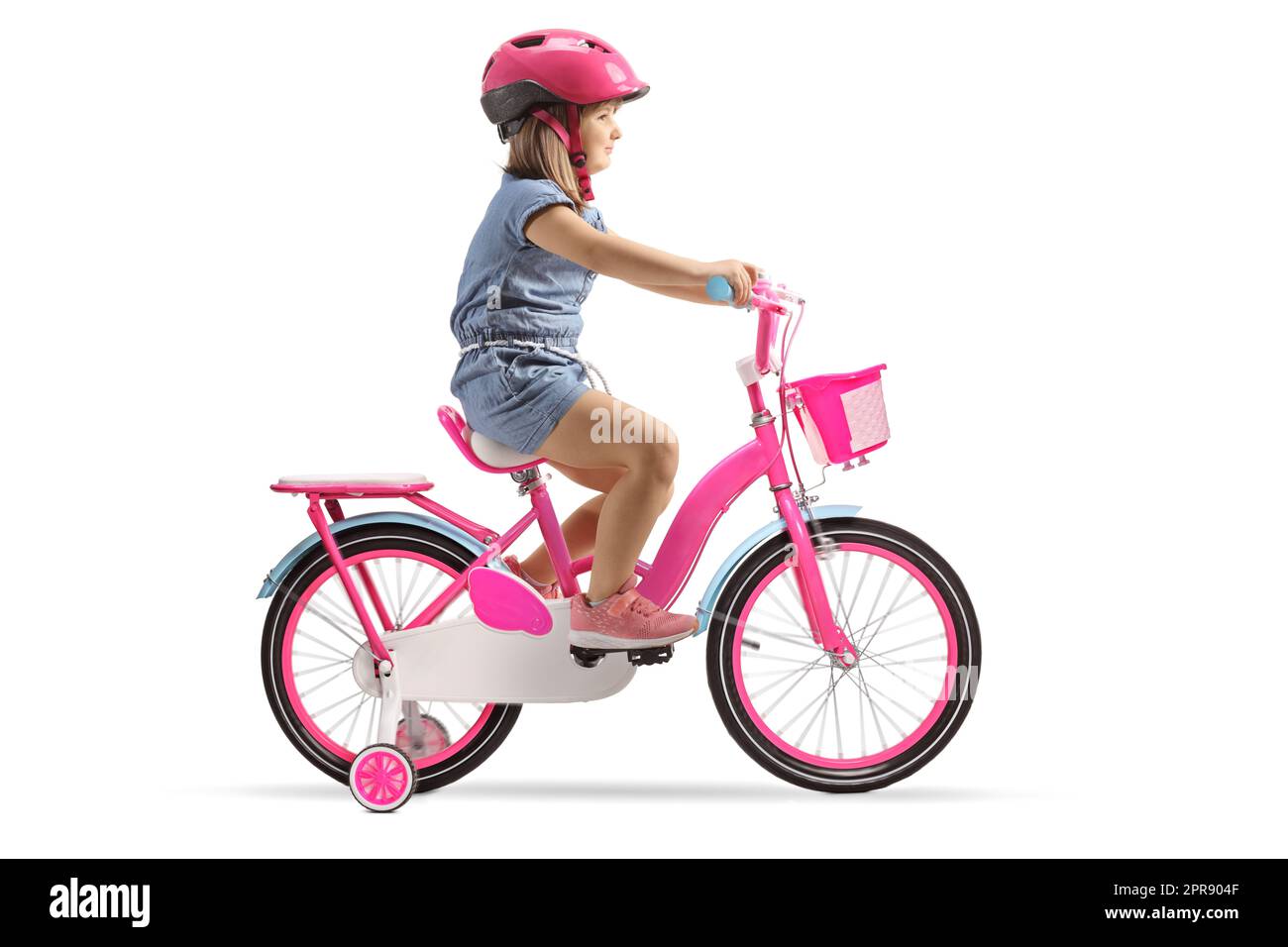 Full length profile shot of a girl with a helmet riding a pink bicycle