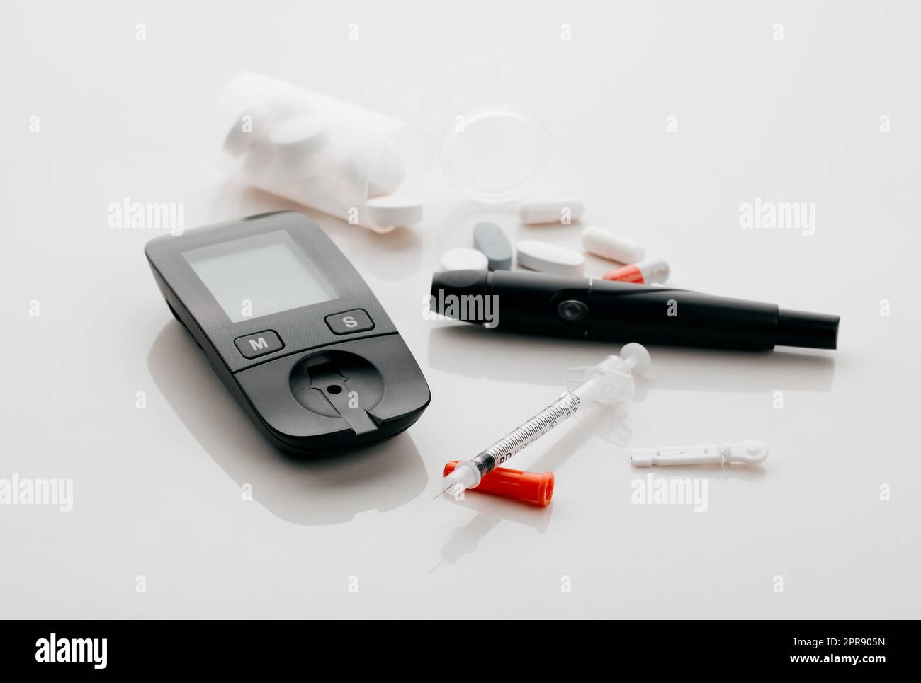 https://c8.alamy.com/comp/2PR905N/the-diabetes-starter-pack-closeup-shot-of-a-blood-glucose-meter-needles-and-pills-in-an-empty-studio-2PR905N.jpg