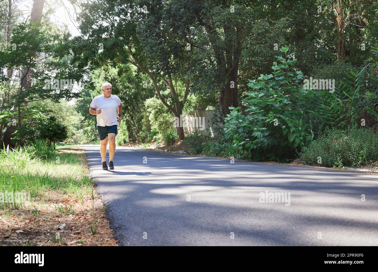 Staying active is essential for everyone. a mature man running outdoors. Stock Photo