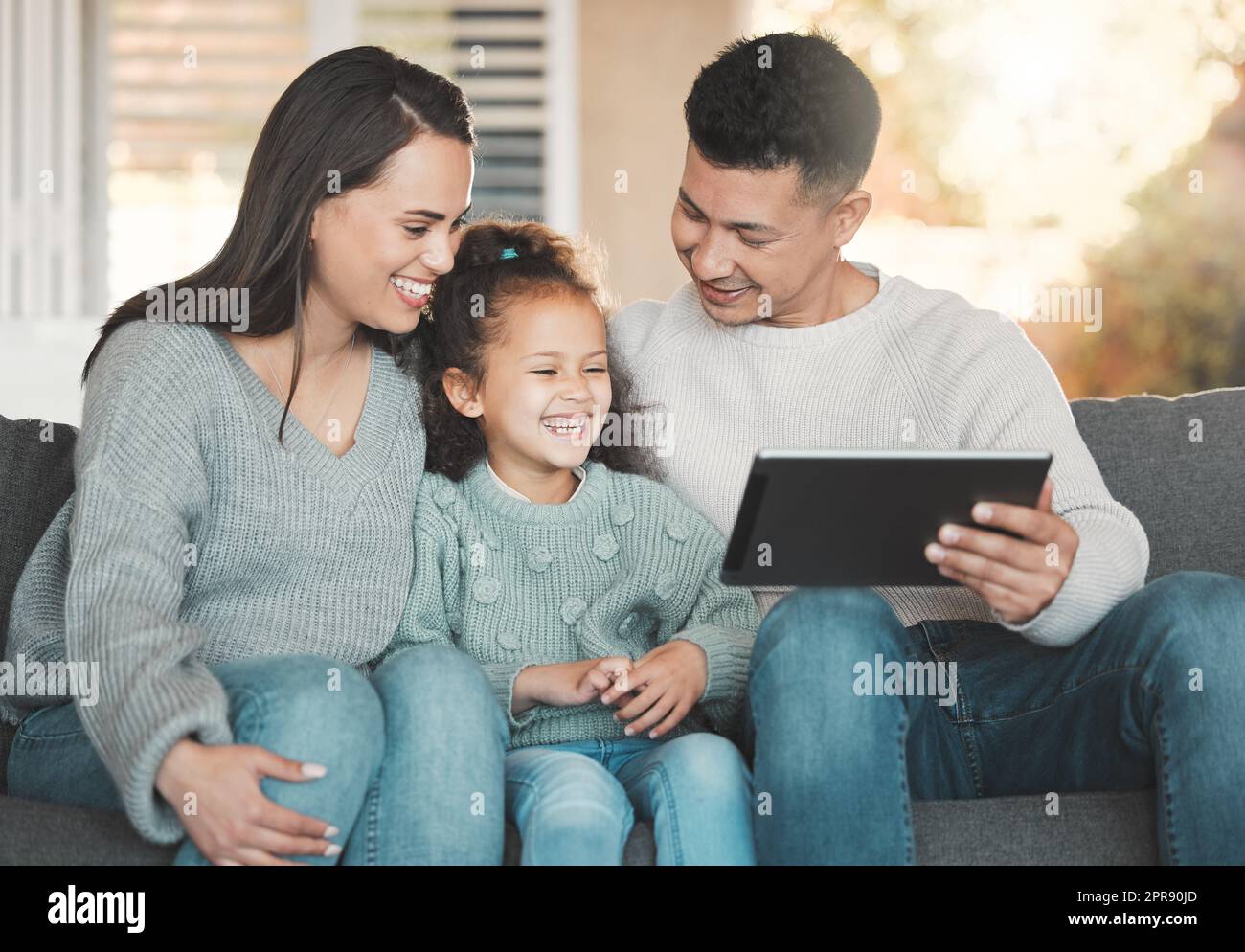 My friends and family are my support system. a young family happily bonding while using a digital tablet together on the sofa at home. Stock Photo