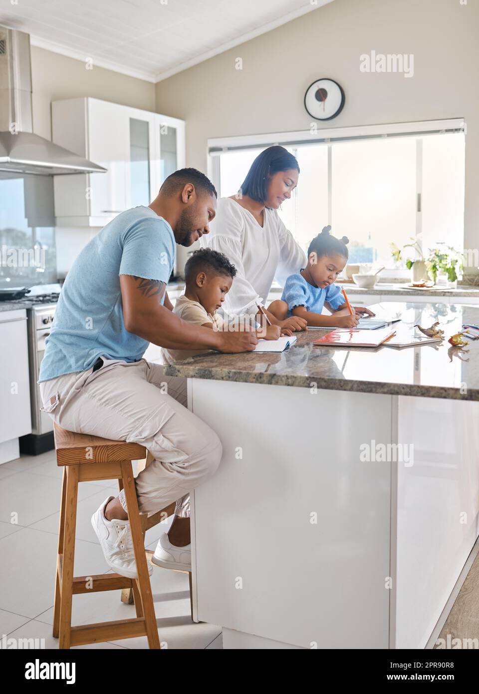 Theyve got our attention. parents helping their children with homework at home. Stock Photo