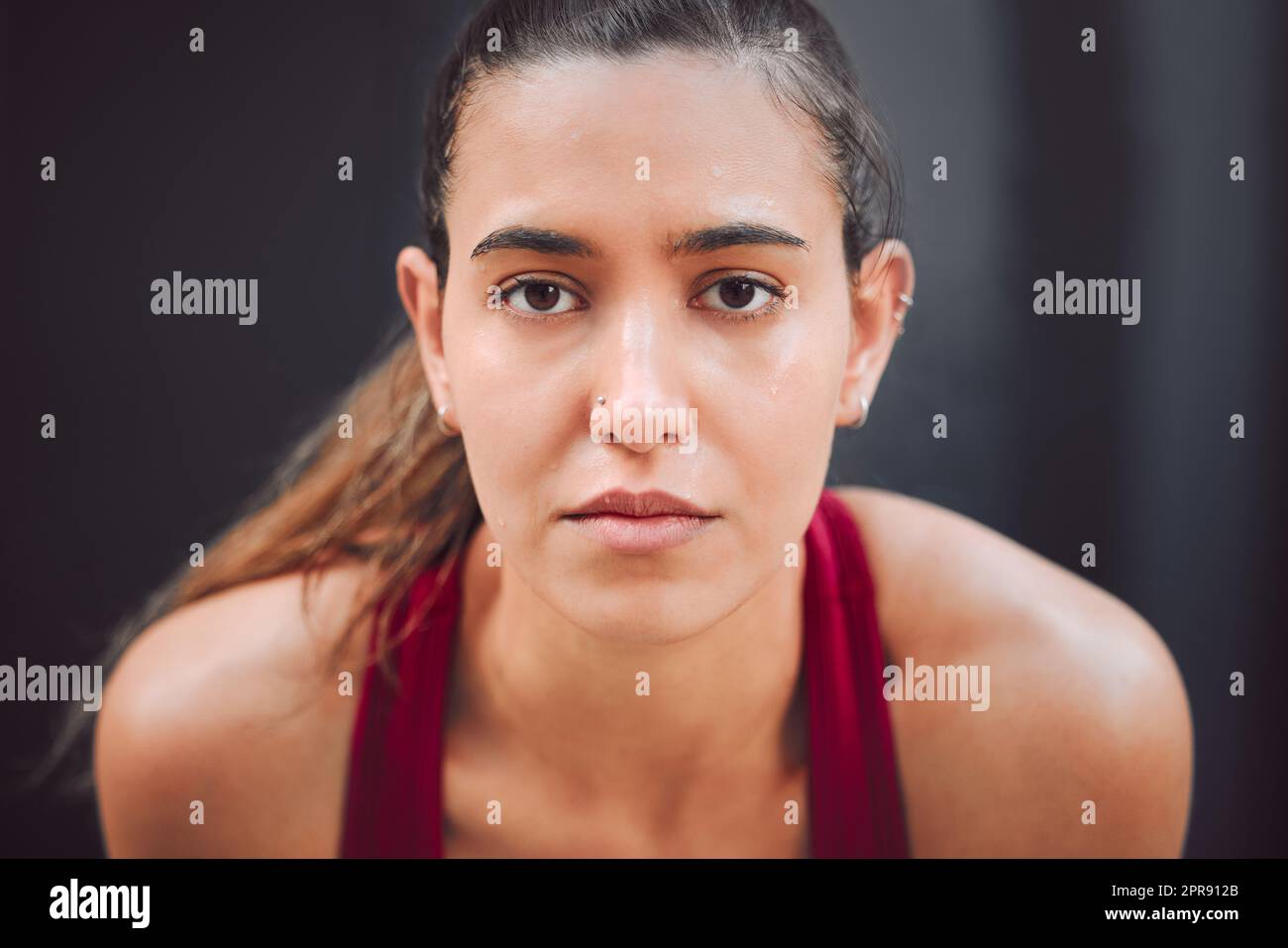 Focused on the run. Cropped portrait of an attractive young female athlete looking tired while running outdoors. Stock Photo