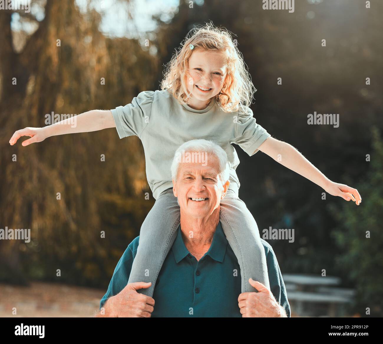 You are altogether beautiful my darling. a girl being carried by her grandfather outside. Stock Photo
