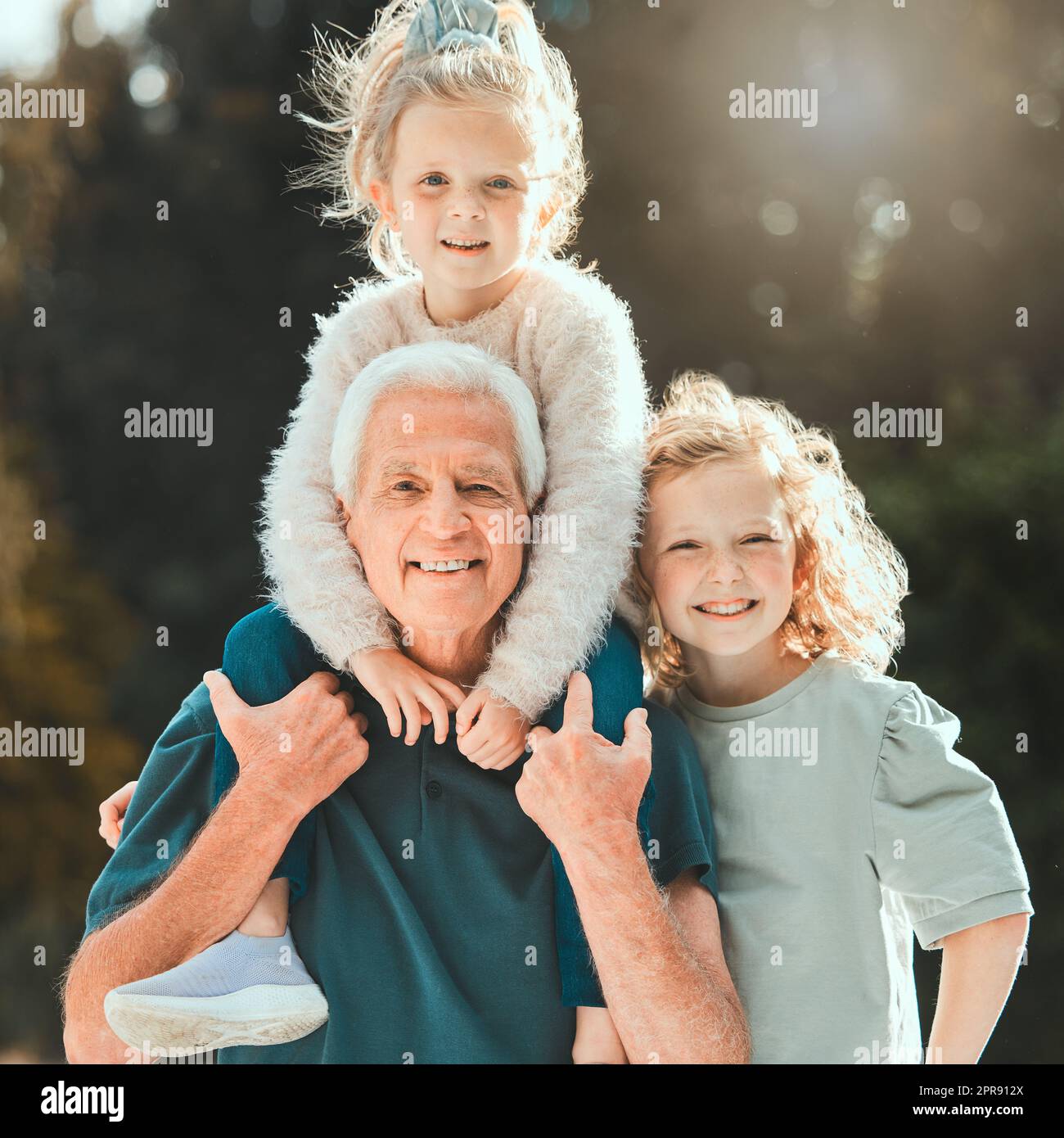 They grow up in the most delightful way. a senior man spending time with his grandchildren outside. Stock Photo